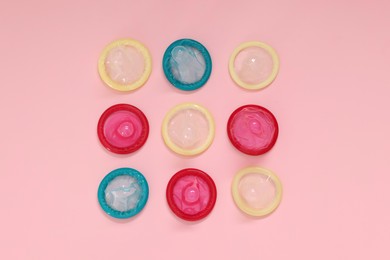 Condoms on pink background, flat lay. Safe sex