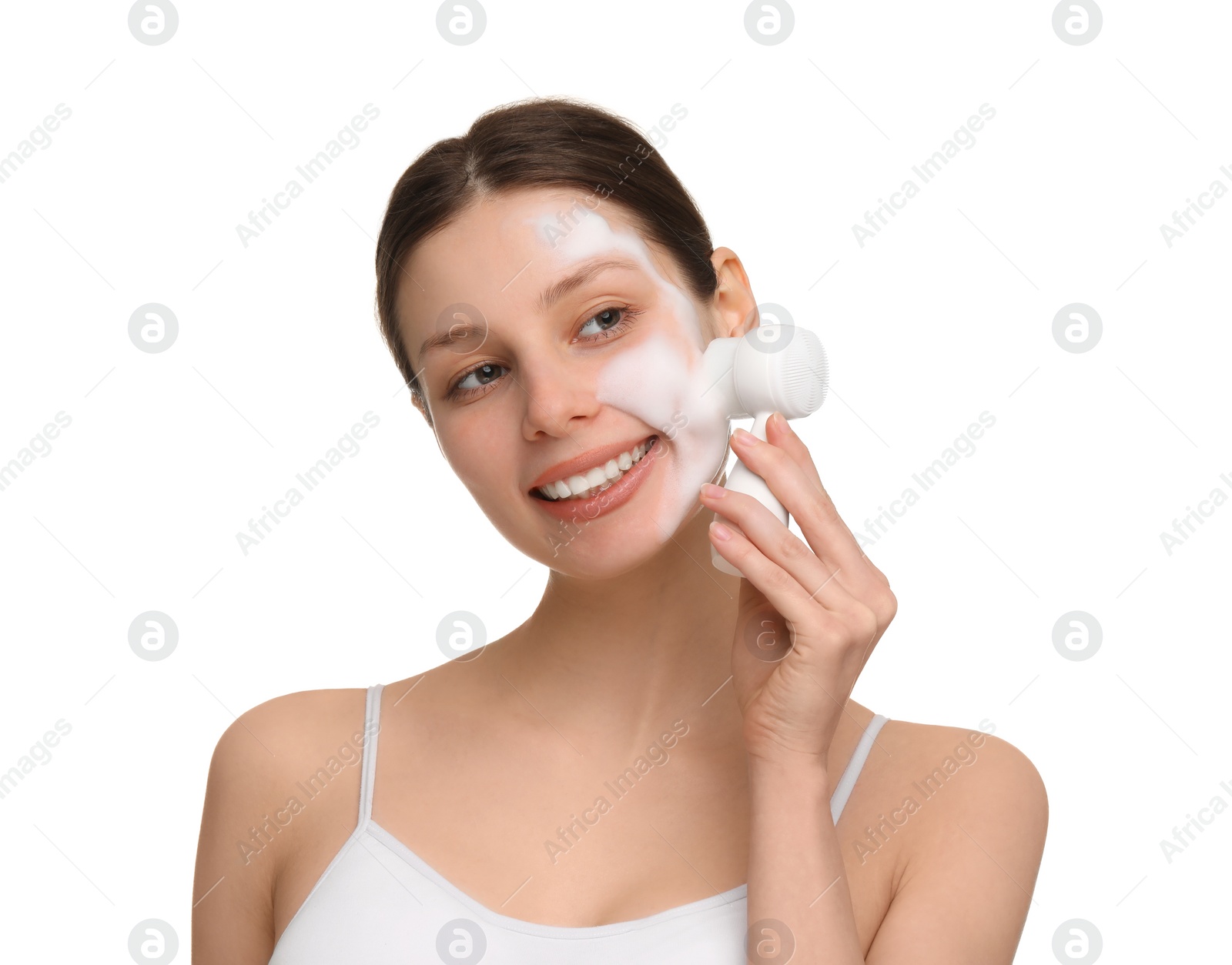 Photo of Young woman washing face with brush and cleansing foam on white background