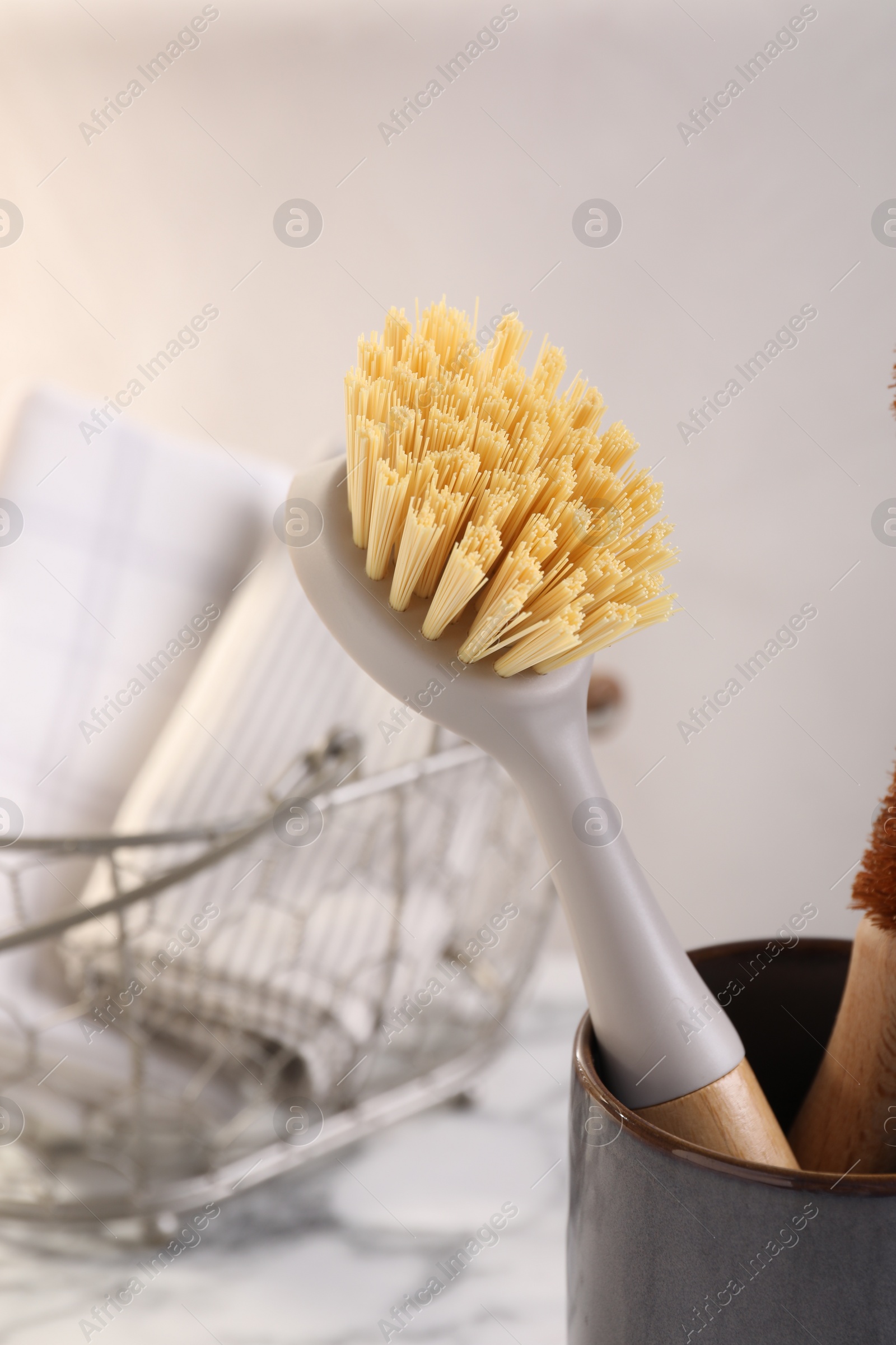 Photo of Cleaning brush in holder on blurred background, closeup