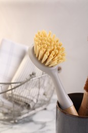 Photo of Cleaning brush in holder on blurred background, closeup