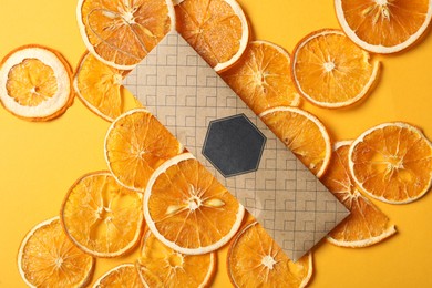 Scented sachet and dried orange slices on yellow background, flat lay