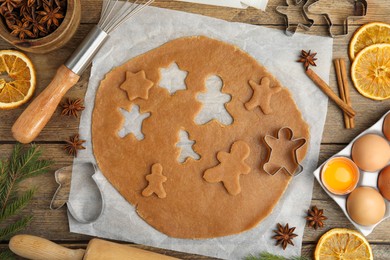 Photo of Flat lay composition with dough and cookie cutters on wooden table. Christmas biscuits