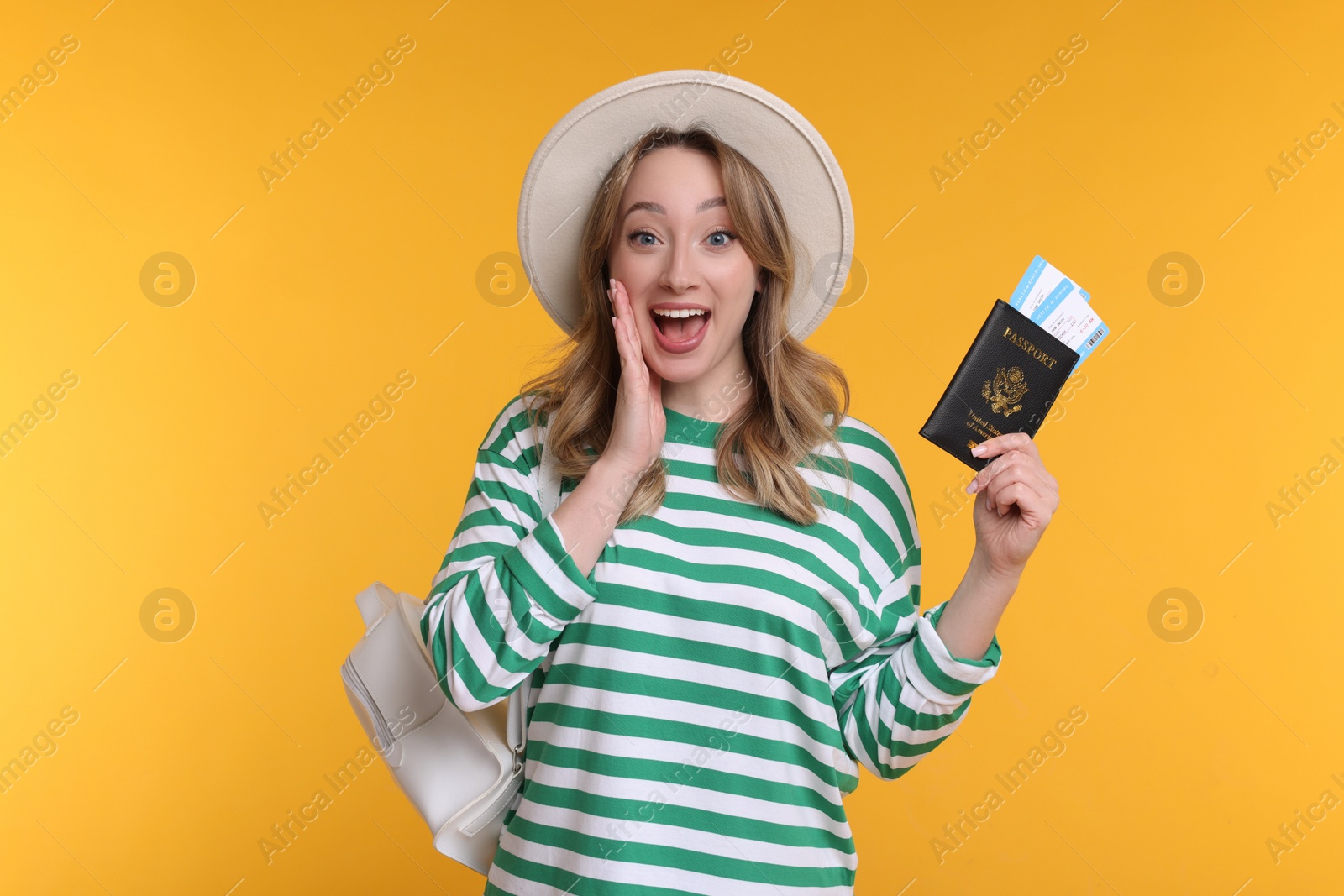 Photo of Emotional young woman with passport, ticket and hat on yellow background