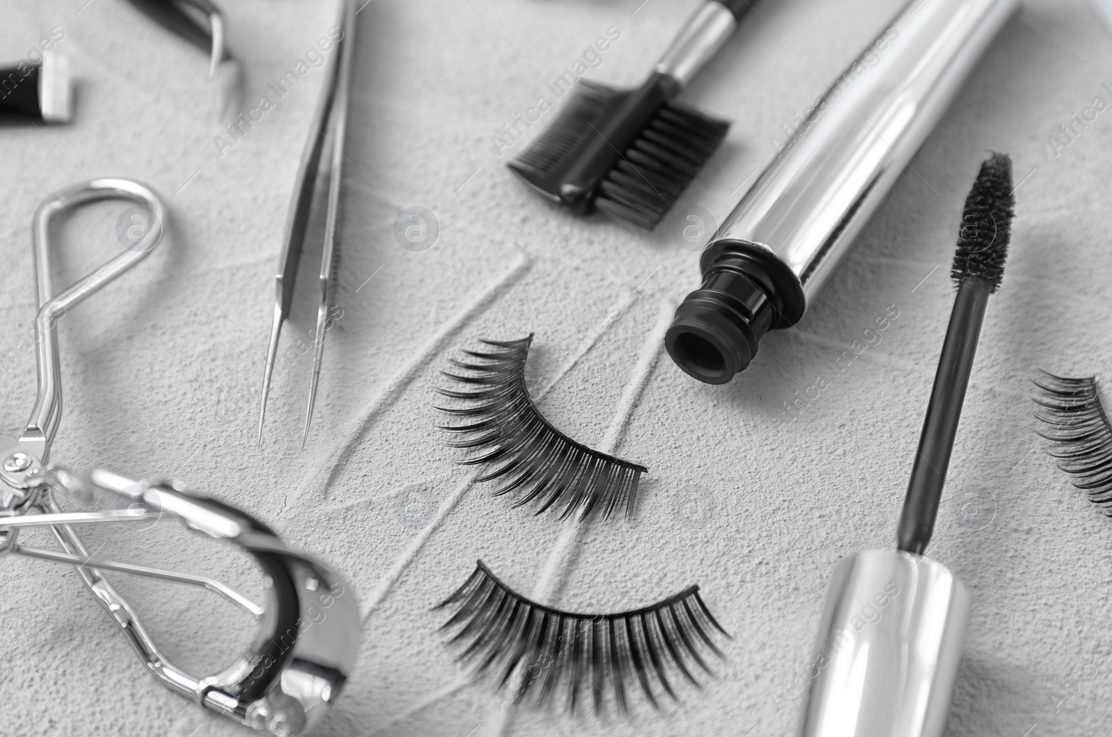 Photo of Composition with false eyelashes and cosmetic tools on grey background