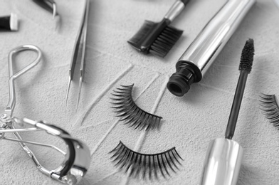 Photo of Composition with false eyelashes and cosmetic tools on grey background