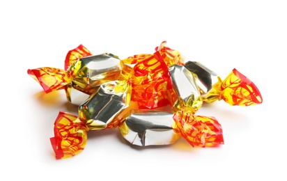 Delicious candies wrapped in foil on white background