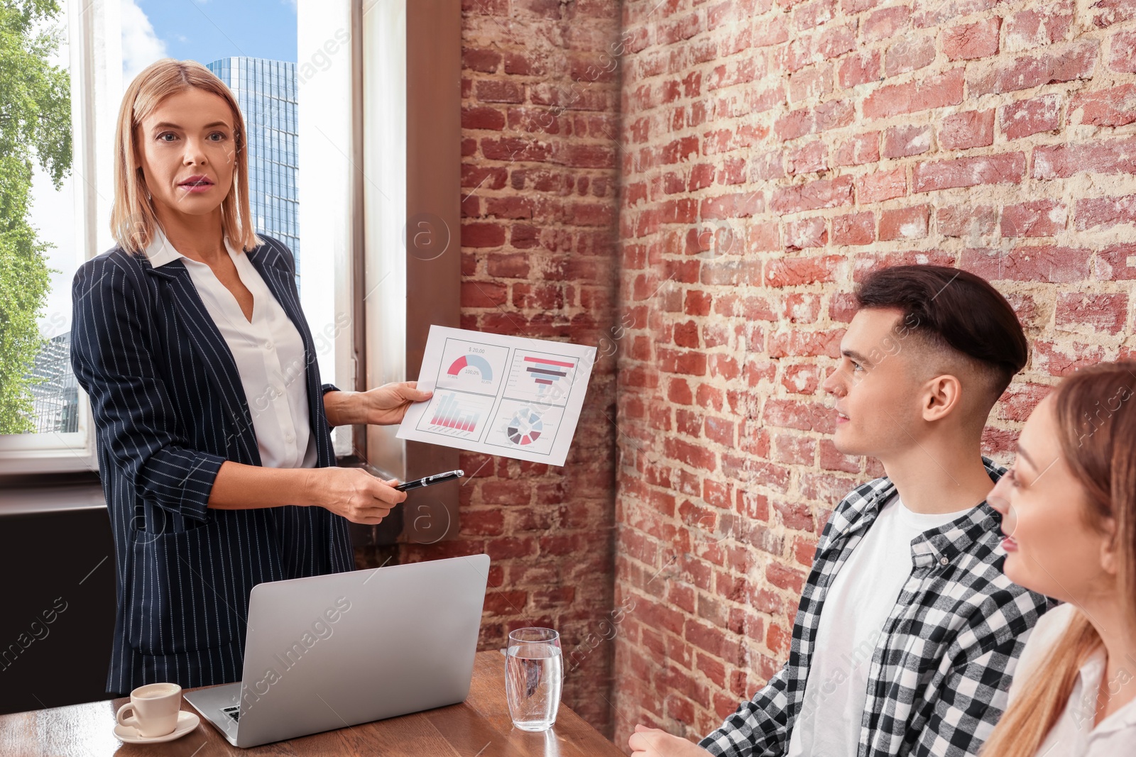 Photo of Businesswoman having meeting with her employees in office. Lady boss