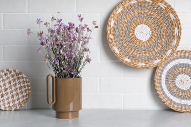 Ceramic vase with dry plants and decor on light table