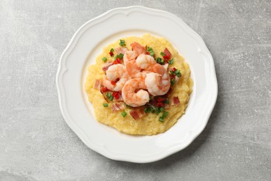 Photo of Plate with fresh tasty shrimps, bacon, grits, green onion and pepper on gray textured table, top view