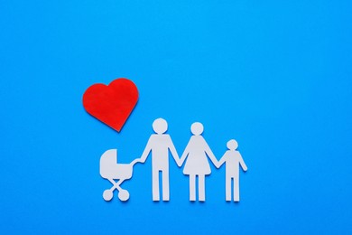 Photo of Paper family cutout and red heart on light blue background, flat lay. Insurance concept