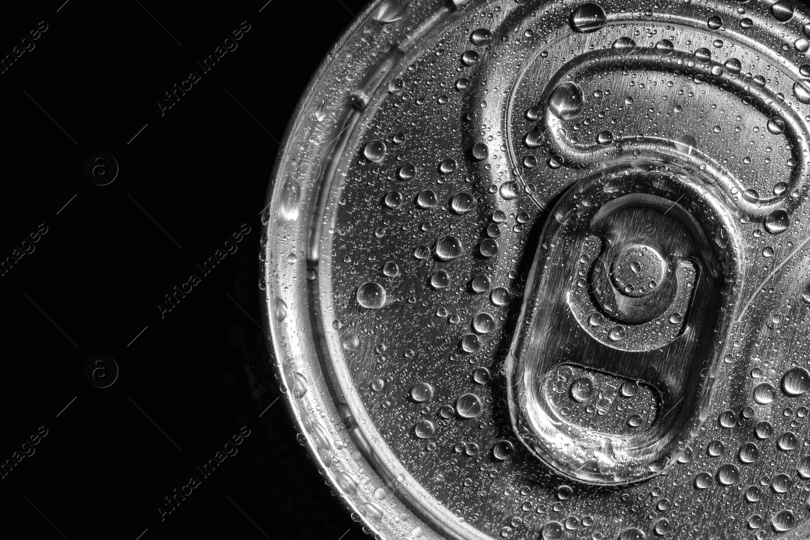 Photo of Aluminum can of beverage covered with water drops on black background, top view. Space for text