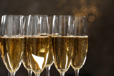 Glasses of champagne on blurred background, closeup. Space for text