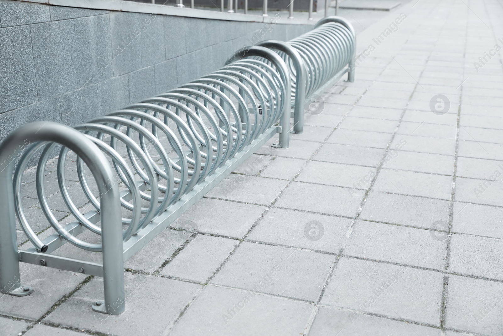 Photo of Spiral bicycle stands on city street. Space for text