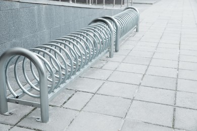 Photo of Spiral bicycle stands on city street. Space for text