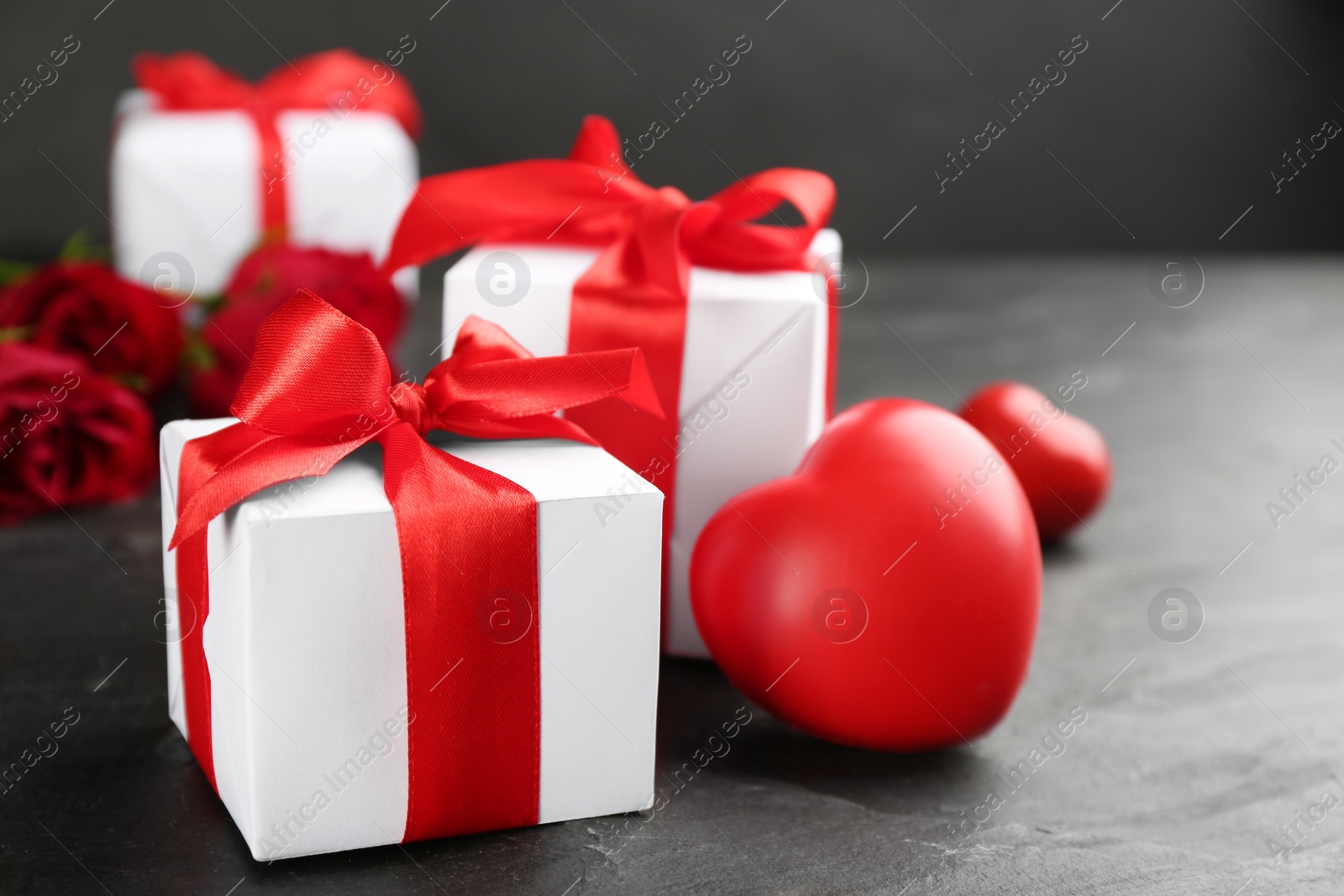 Photo of Beautiful gift box and red heart on black table, closeup. Valentine's Day celebration