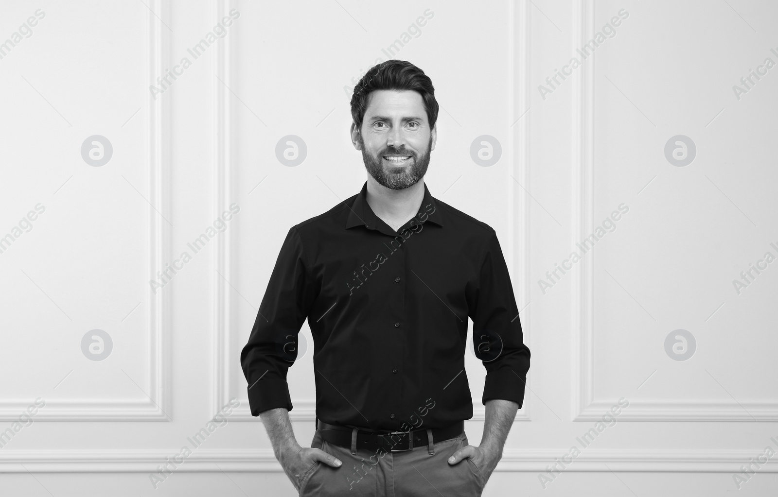 Image of Portrait of handsome man against light wall. Black and white effect