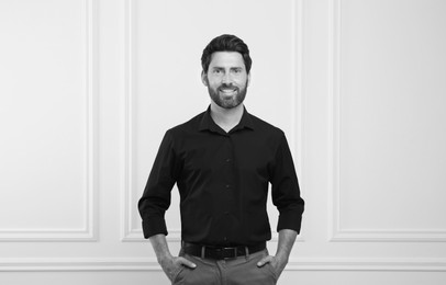 Image of Portrait of handsome man against light wall. Black and white effect