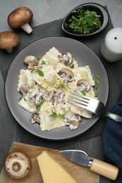 Photo of Delicious ravioli with ingredients on black table, flat lay