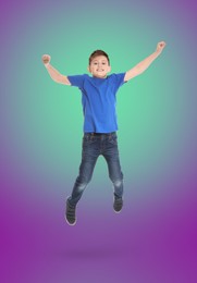 Happy boy jumping on color gradient background