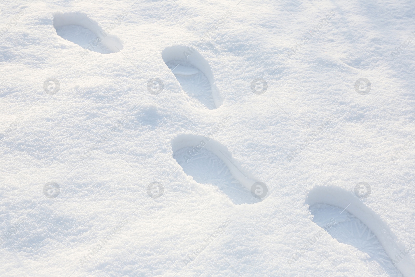 Photo of Footprints on white snow outdoors. Winter season