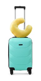 Photo of Soft travel pillow on turquoise suitcase isolated on white