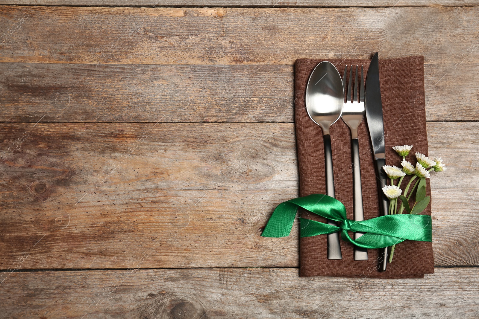 Photo of Cutlery and napkin on wooden background, top view. Table setting