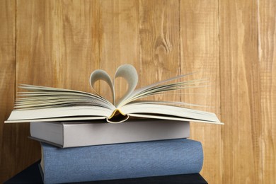 Photo of Stack of hardcover books on wooden background, space for text