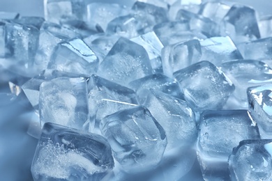 Pile of ice cubes on color background, closeup