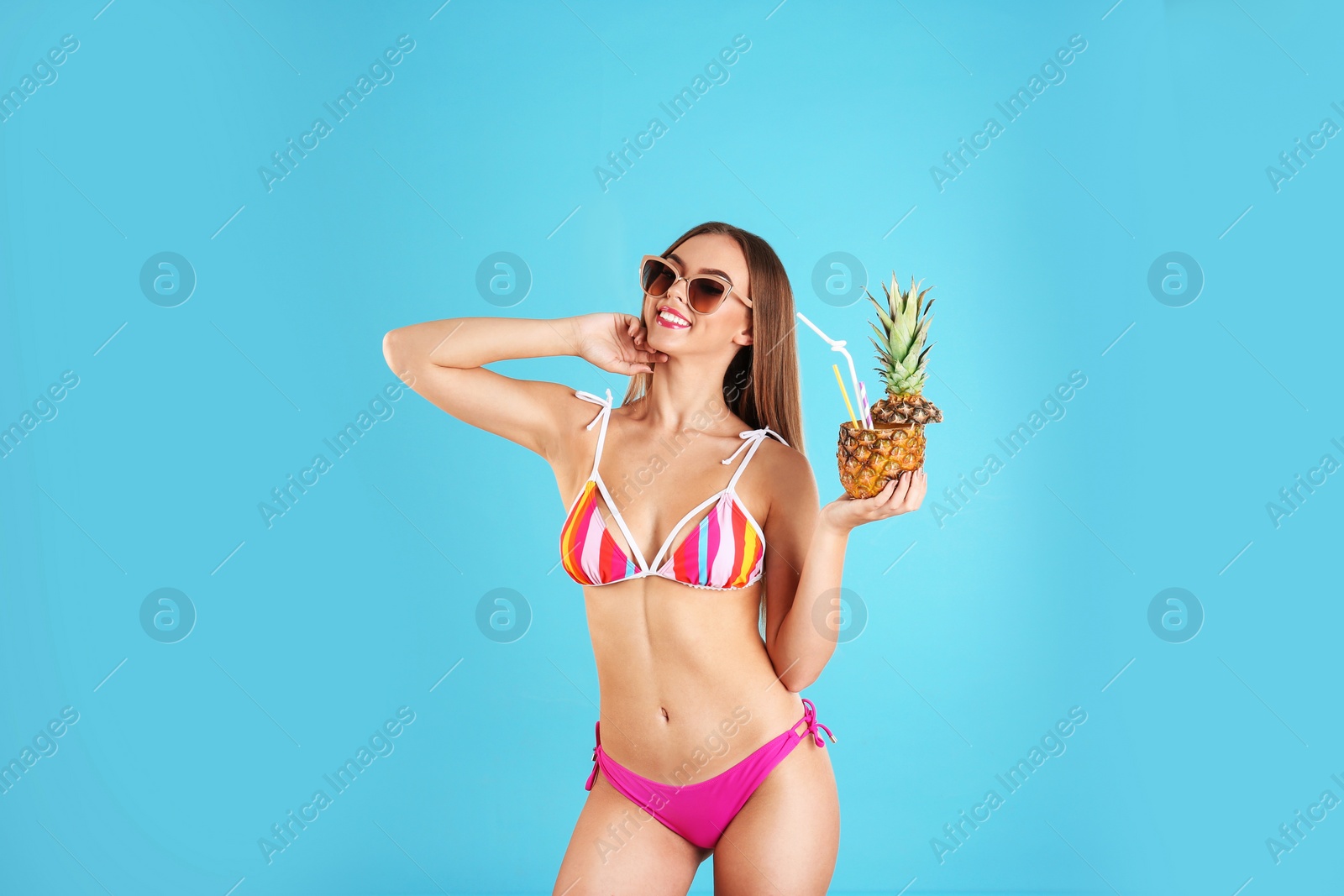 Photo of Pretty sexy woman in stylish bikini with cocktail on color background