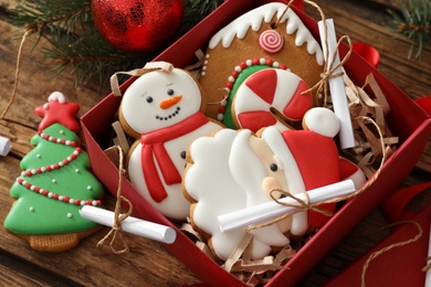 Christmas cookies in gift box and festive decor on wooden table, closeup. Advent calendar