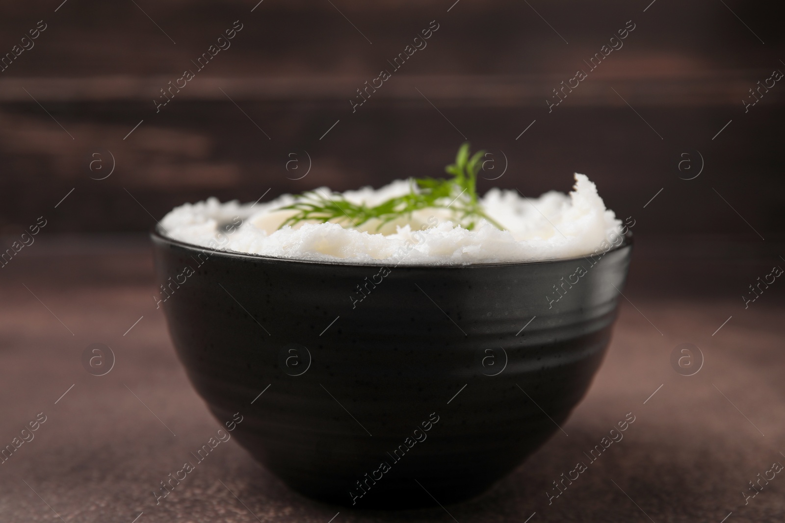 Photo of Delicious pork lard with dill in bowl on brown table