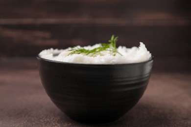 Photo of Delicious pork lard with dill in bowl on brown table