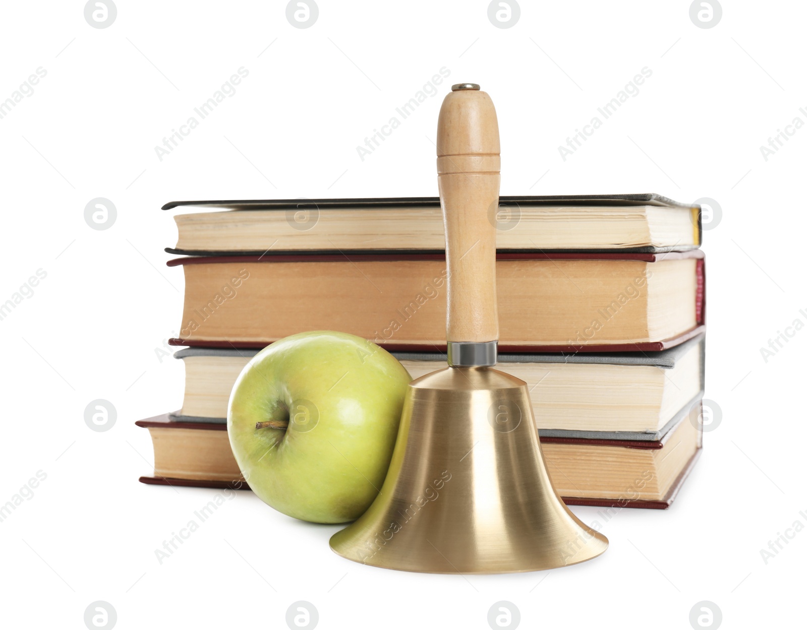 Photo of Golden school bell with wooden handle, apple and stack of books on white background