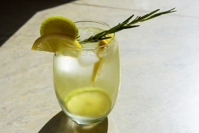 Photo of Tasty refreshing lemonade on light grey table. Summer drink