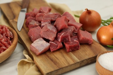 Cut beef meat and products on white table, closeup