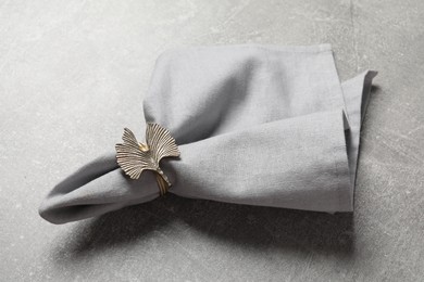 Photo of Fabric napkin and decorative ring for table setting on gray background,