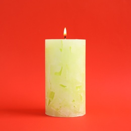 Alight scented wax candle on color background