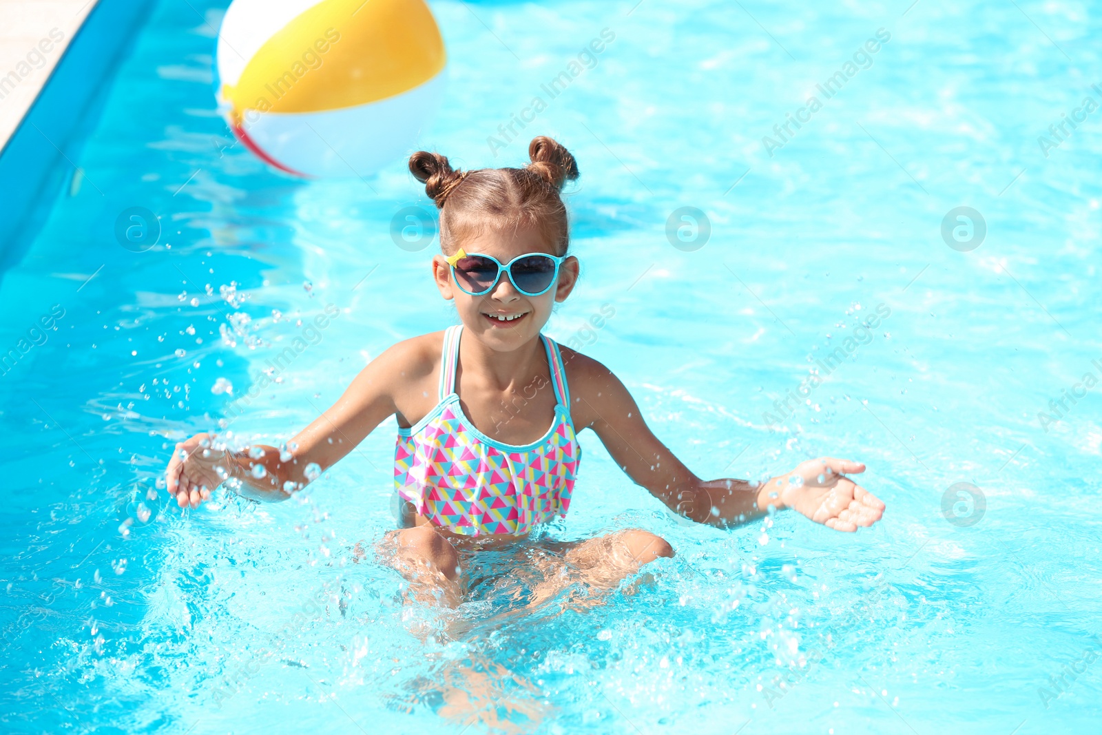 Photo of Happy little girl having fun in swimming pool