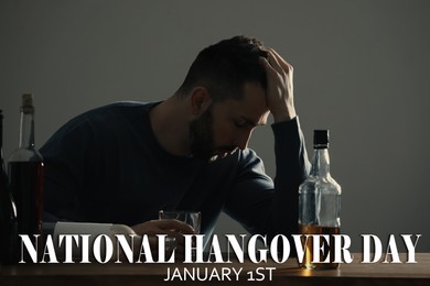 Image of National hangover day - January 1st. Man with alcohol drink at table