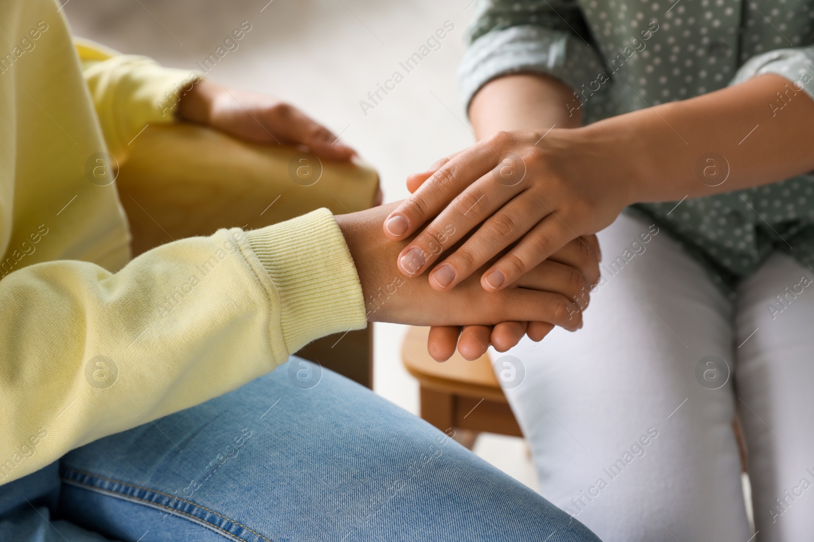 Photo of Psychotherapist holding patient's hand in office, closeup