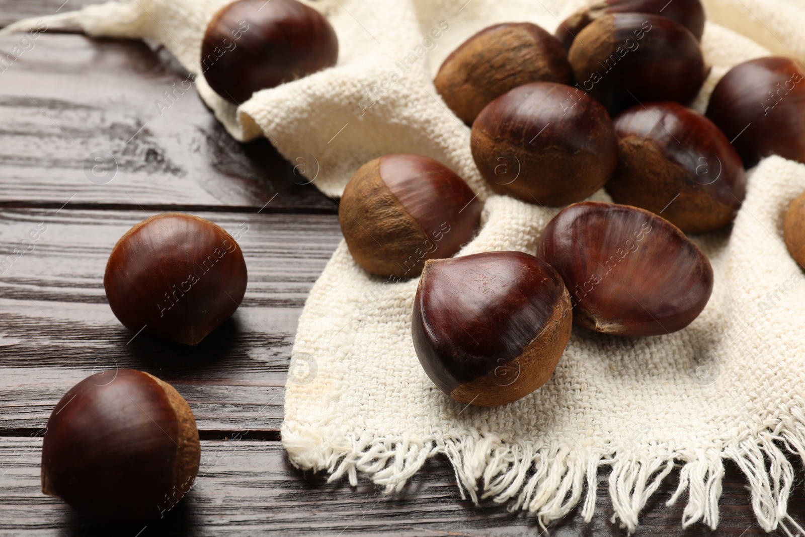 Photo of Sweet fresh edible chestnuts on wooden table, closeup