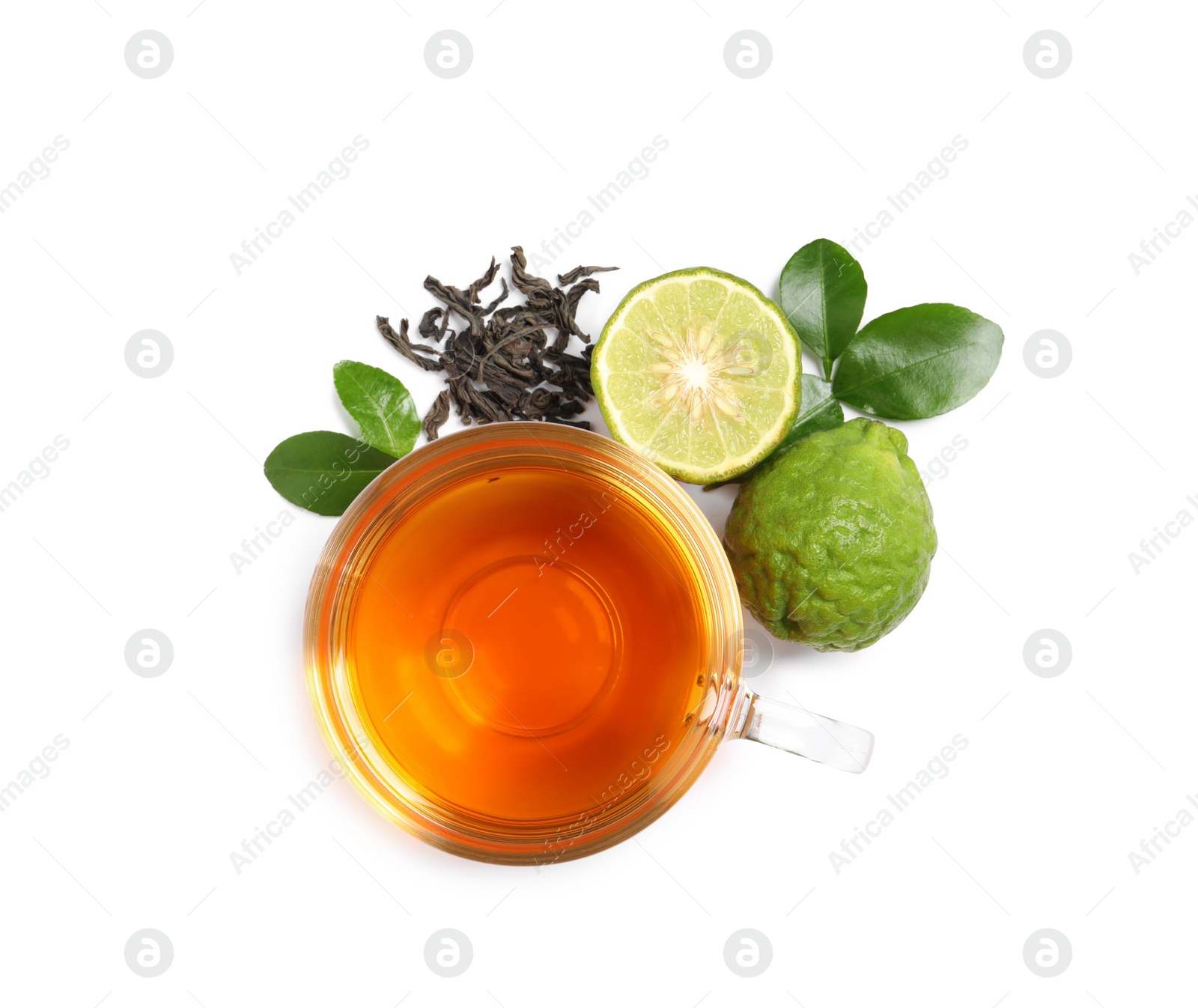 Photo of Glass cup of tasty bergamot tea, dry leaves and fresh fruits on white background, top view