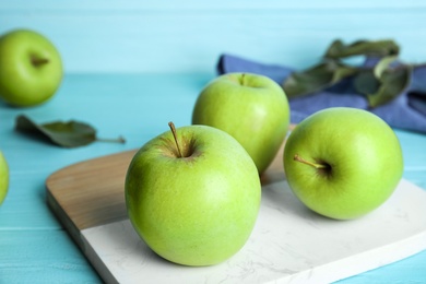 Photo of Ripe green apples on light blue wooden table