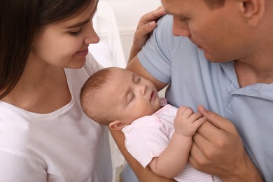 Happy family with their sleeping baby indoors, closeup