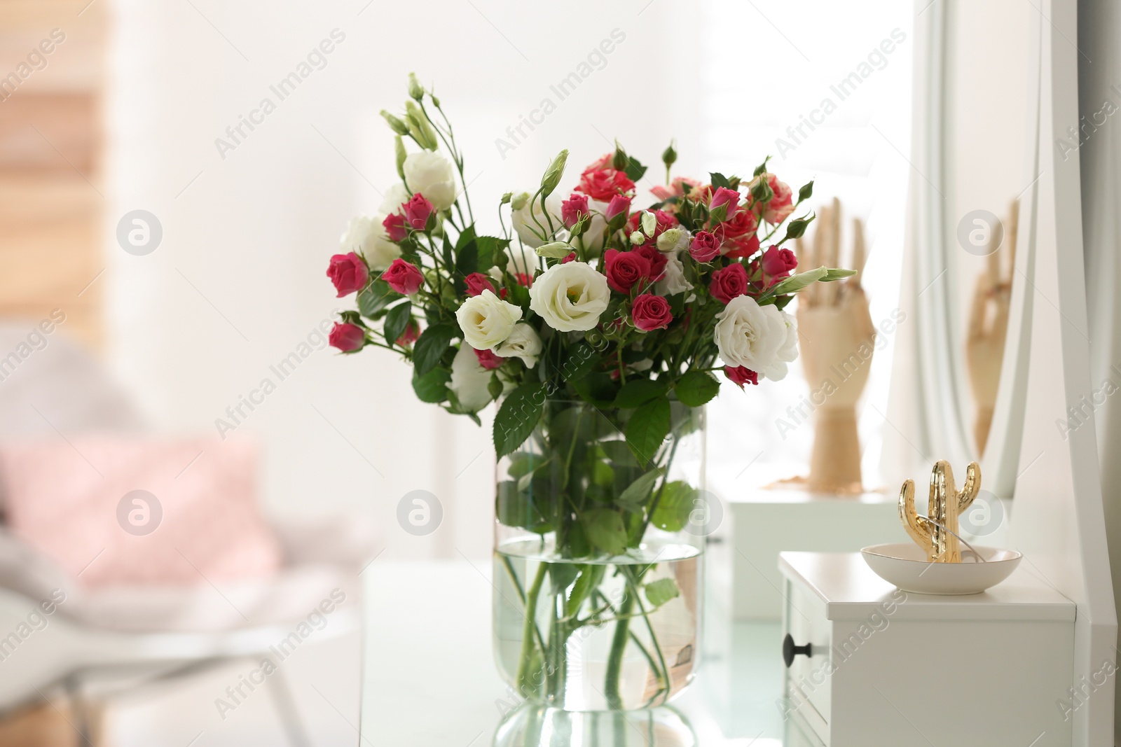 Photo of Glass vase with fresh flowers on dressing table indoors