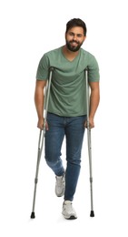 Photo of Young man with axillary crutches on white background