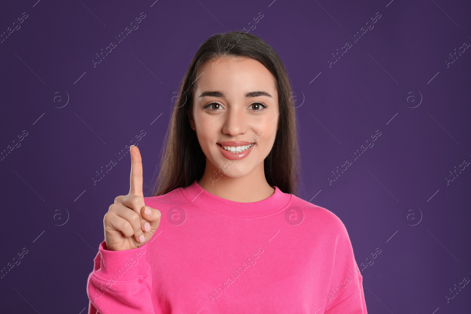 Photo of Woman showing number one with her hand on purple background