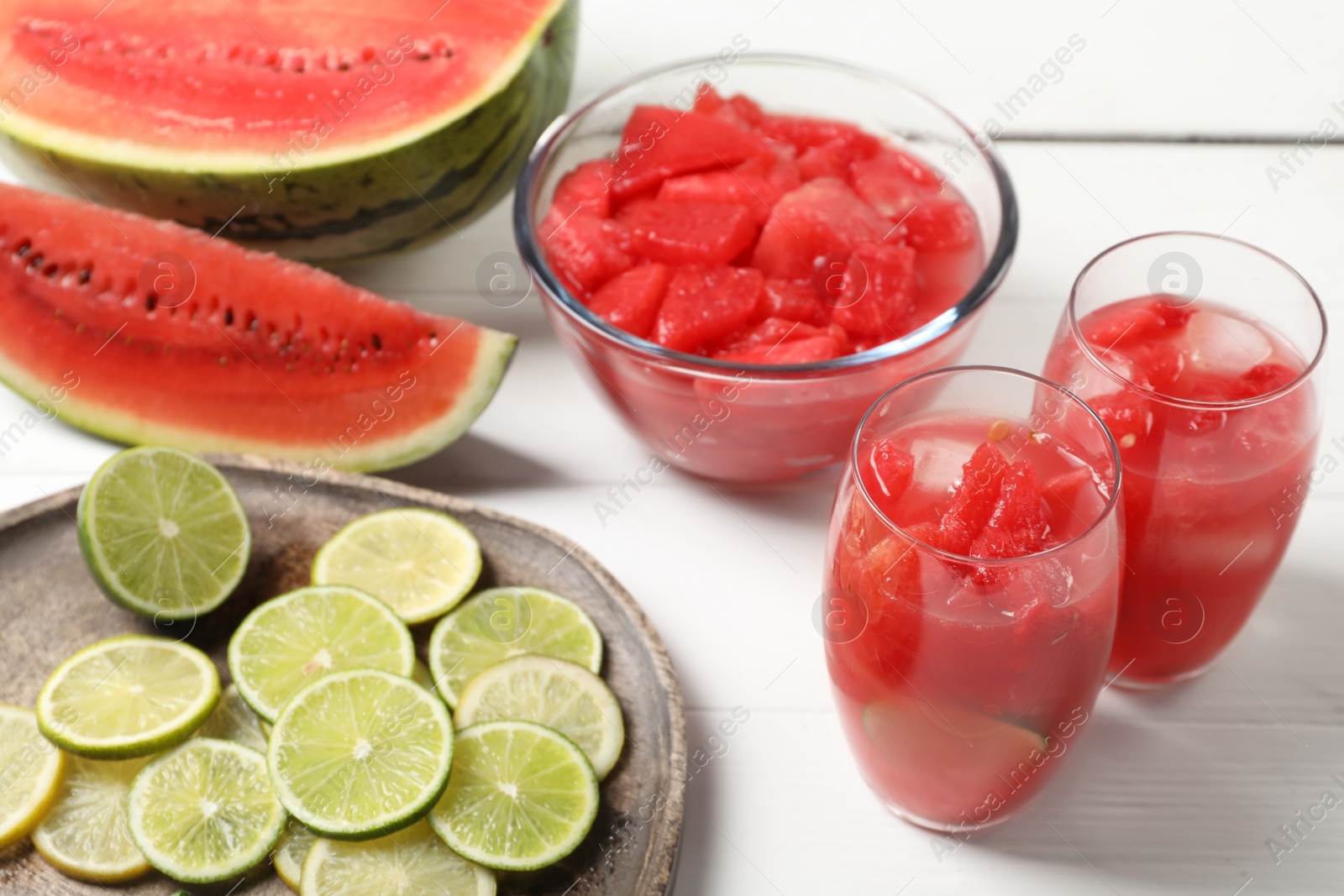 Photo of Fresh watermelon drink with lime and ingredients on white wooden table