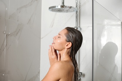 Image of Beautiful young woman taking shower at home
