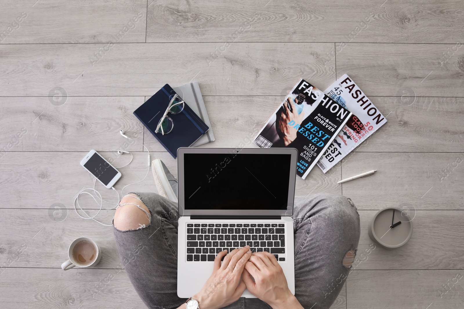 Photo of Young man with laptop sitting on floor, top view